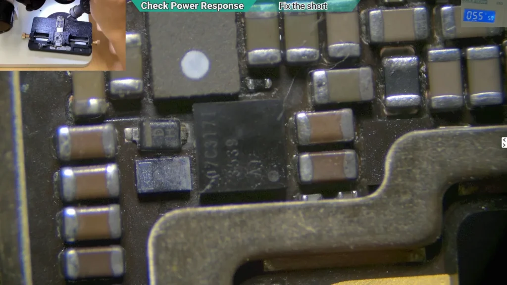 Microscope image highlighting the overheated backlight IC on a water-damaged iPhone motherboard before removal.