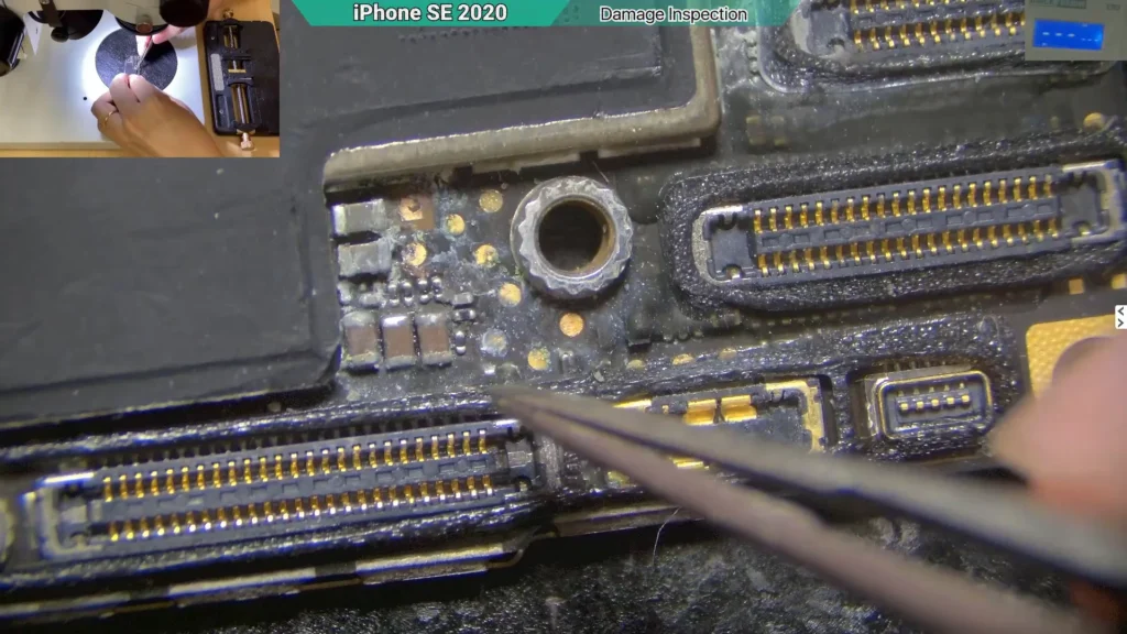 Microscope view of corrosion on the circuit of a water-damaged near battery connector iPhone