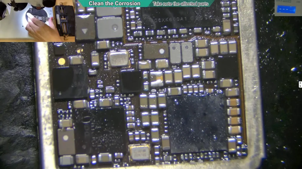 Close-up microscope image of a cleaned area on a water-damaged iPhone motherboard following corrosion removal on audio circuit