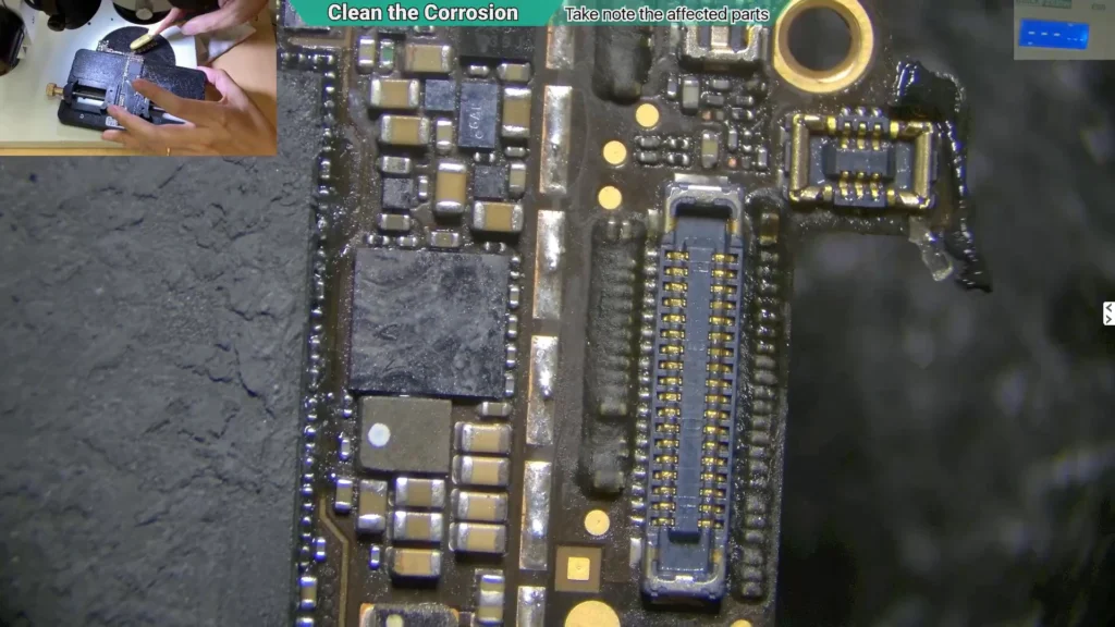 Close-up microscope image of a cleaned area on a water-damaged iPhone motherboard following corrosion under the shield