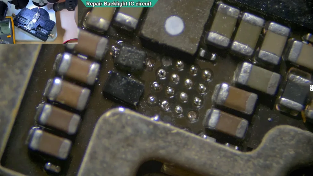 Microscope image showing the repaired backlight circuit with replacement diodes installed and two missing solder pads awaiting reconstruction.