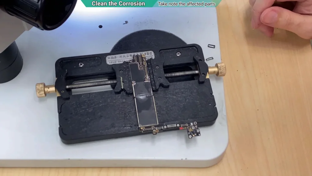 Water-damaged iPhone motherboard before the protective metal shield was removed for further inspection.