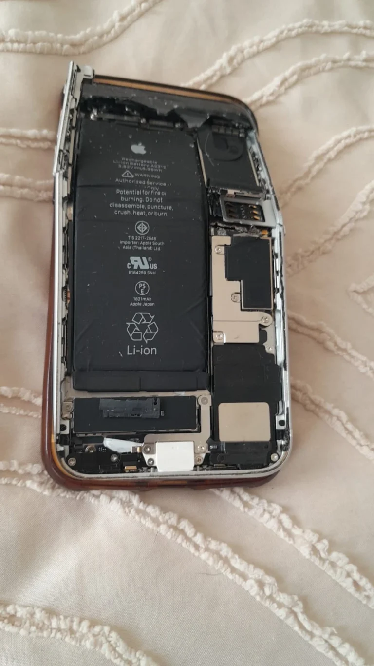 Front view showing the severe physical deformation of the damaged iPhone
