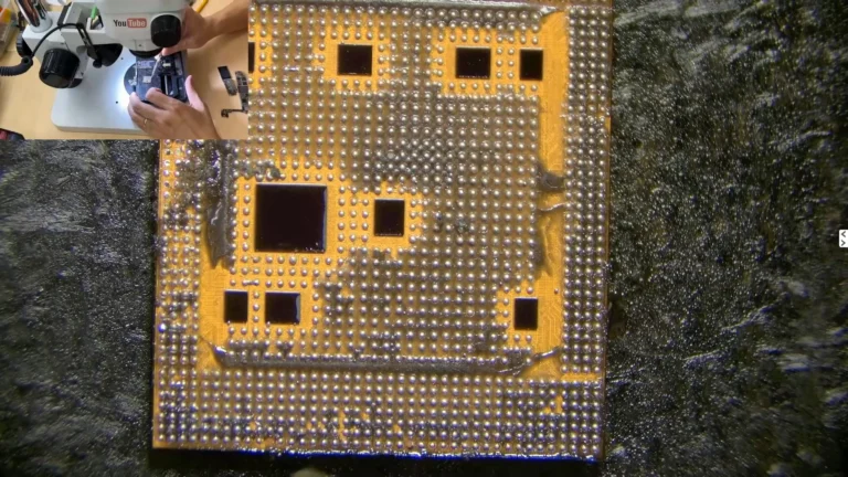 Original iPhone CPU after removal with black underfill glue still visible around the chip